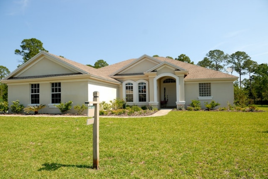 A house with a for sale sign in front yard